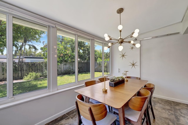 dining space with a wealth of natural light, a notable chandelier, and baseboards