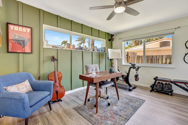 office space with baseboards, wood finished floors, and a ceiling fan