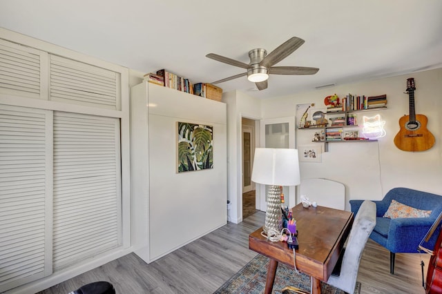living area with a ceiling fan and wood finished floors