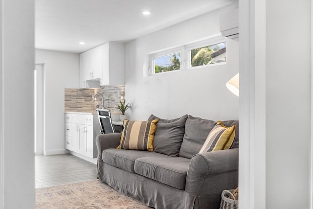 living room with wet bar, light wood-type flooring, a wall mounted AC, and recessed lighting