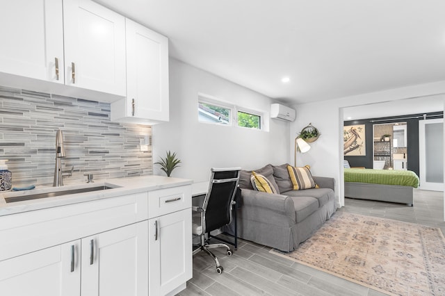 office featuring a sink, wood finish floors, an AC wall unit, and recessed lighting