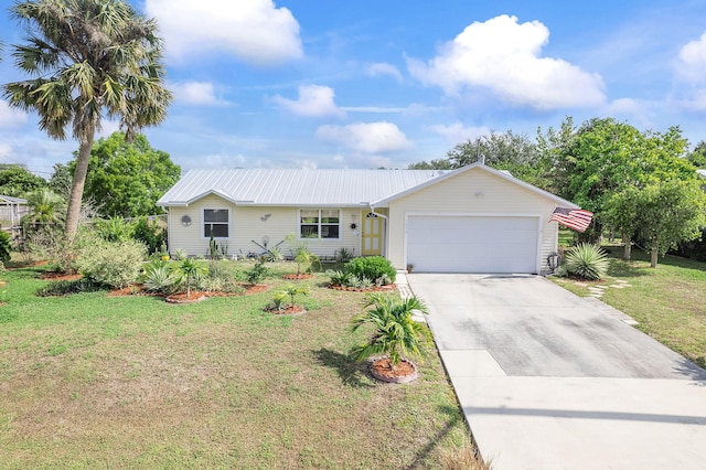 ranch-style house featuring a garage, a front yard, concrete driveway, and metal roof