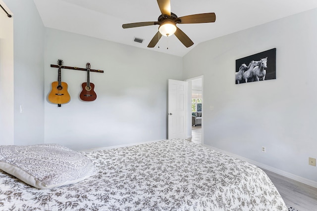bedroom featuring lofted ceiling, light wood-style flooring, baseboards, and ceiling fan