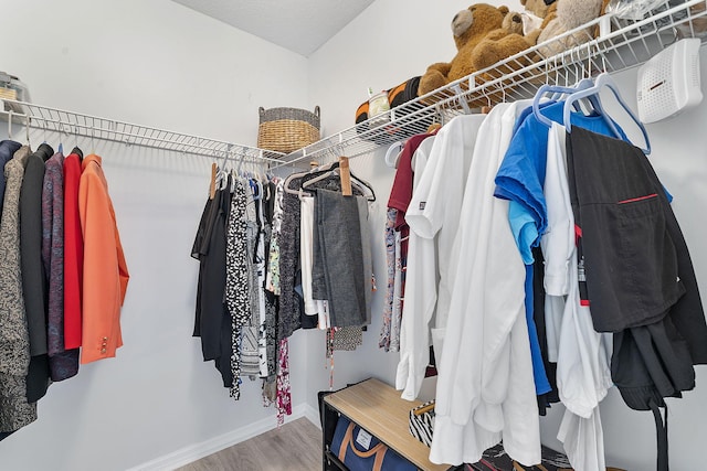 walk in closet with wood finished floors