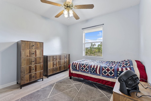 bedroom with wood finished floors, a ceiling fan, and baseboards