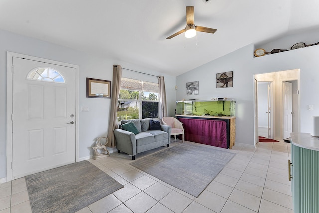foyer entrance with vaulted ceiling, ceiling fan, light tile patterned floors, and baseboards