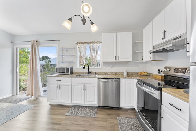 kitchen with appliances with stainless steel finishes, under cabinet range hood, a sink, open shelves, and white cabinetry