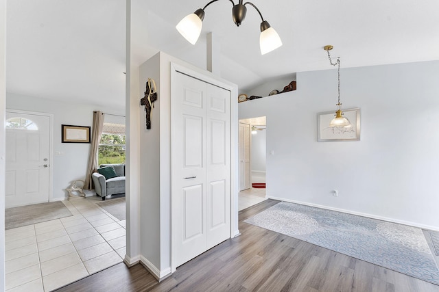 entryway featuring vaulted ceiling, wood finished floors, and baseboards