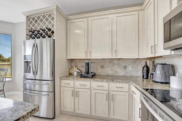 12774 Spikerush Cir, Boca Raton, FL 33428 - kitchen featuring light tile patterned floors, baseboards, light stone counters, tasteful backsplash, and appliances with stainless steel finishes