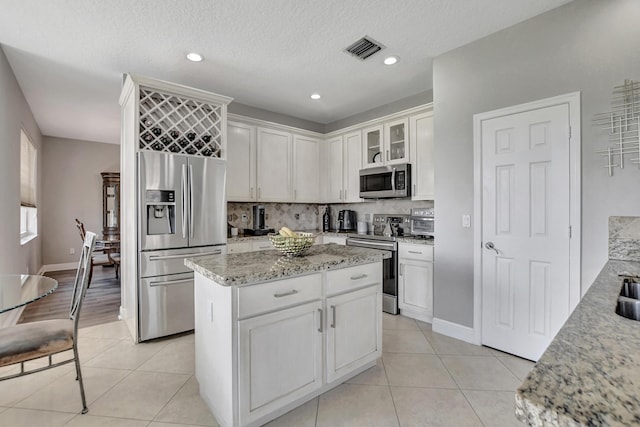 12774 Spikerush Cir, Boca Raton, FL 33428 - kitchen featuring visible vents, light tile patterned flooring, white cabinetry, decorative backsplash, and appliances with stainless steel finishes