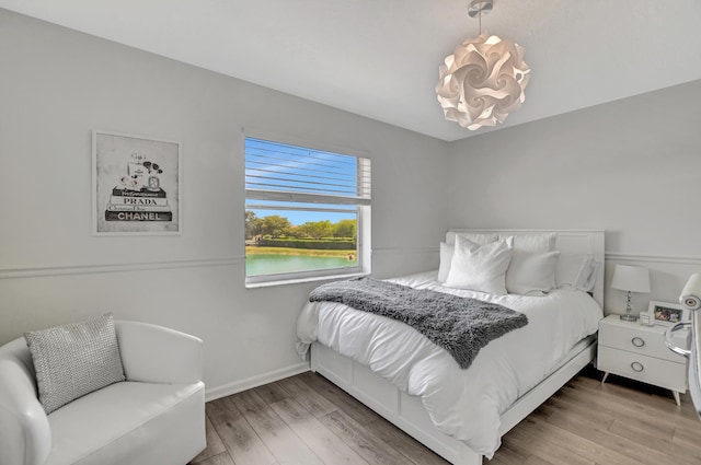 12774 Spikerush Cir, Boca Raton, FL 33428 - bedroom featuring an inviting chandelier, a water view, and wood finished floors