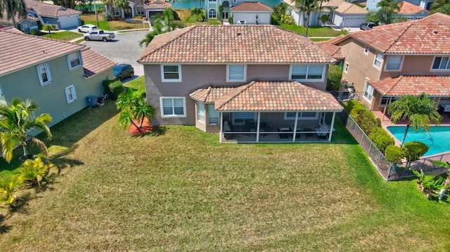 12774 Spikerush Cir, Boca Raton, FL 33428 - rear view of property with a lawn, a tiled roof, stucco siding, a sunroom, and a residential view