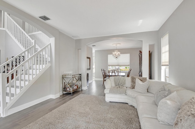 12774 Spikerush Cir, Boca Raton, FL 33428 - living room featuring a notable chandelier, visible vents, wood finished floors, arched walkways, and stairway