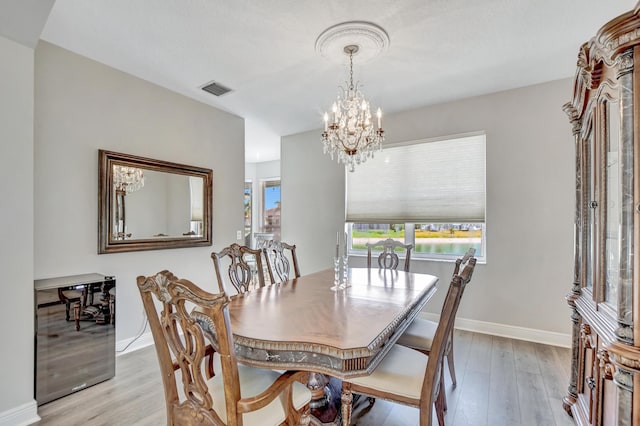 12774 Spikerush Cir, Boca Raton, FL 33428 - dining space with light wood finished floors, an inviting chandelier, visible vents, and plenty of natural light