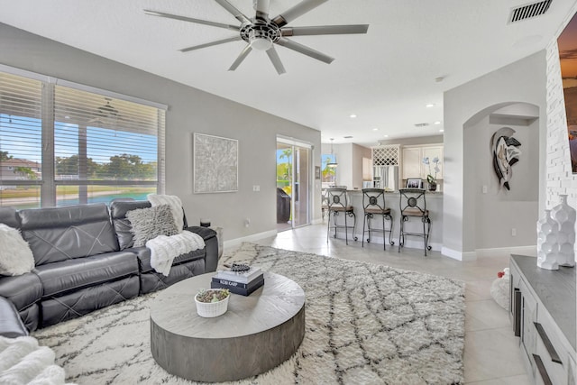 12774 Spikerush Cir, Boca Raton, FL 33428 - living area with visible vents, baseboards, a ceiling fan, and arched walkways
