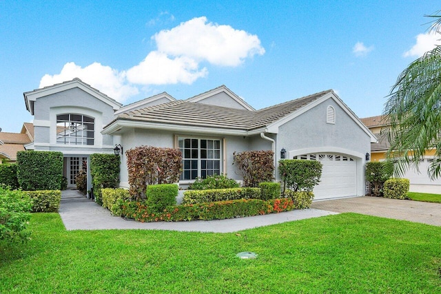 single story home featuring driveway, a front yard, and an attached garage