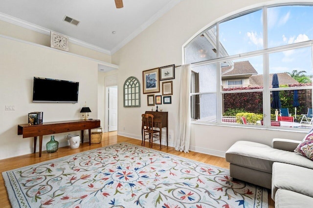 interior space featuring wood finished floors, ornamental molding, visible vents, ceiling fan, and baseboards