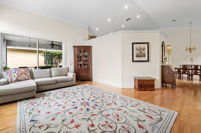 living room with baseboards, ornamental molding, visible vents, and light wood-style floors