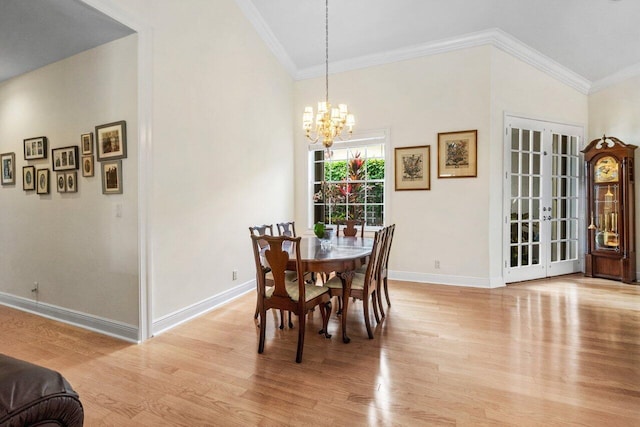 dining room with an inviting chandelier, light wood-style floors, vaulted ceiling, and baseboards