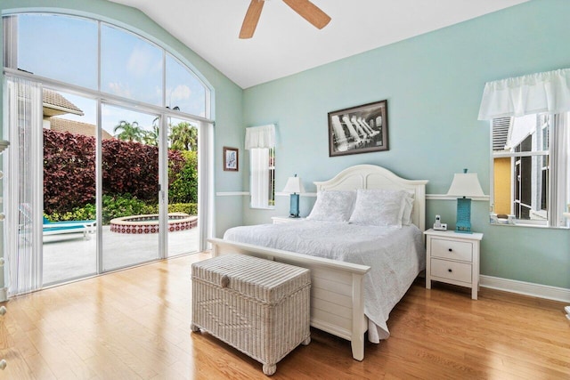 bedroom with a ceiling fan, baseboards, vaulted ceiling, wood finished floors, and access to exterior