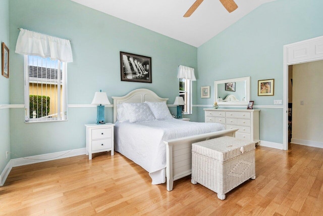 bedroom with a ceiling fan, light wood-style flooring, baseboards, and high vaulted ceiling