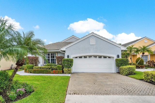 8271 Bob O Link Dr, West Palm Beach, FL 33412 - ranch-style house with an attached garage, decorative driveway, a front lawn, stucco siding, and a tile roof