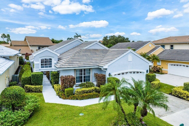 view of front facade featuring a garage, central AC, stucco siding, a front yard, and driveway