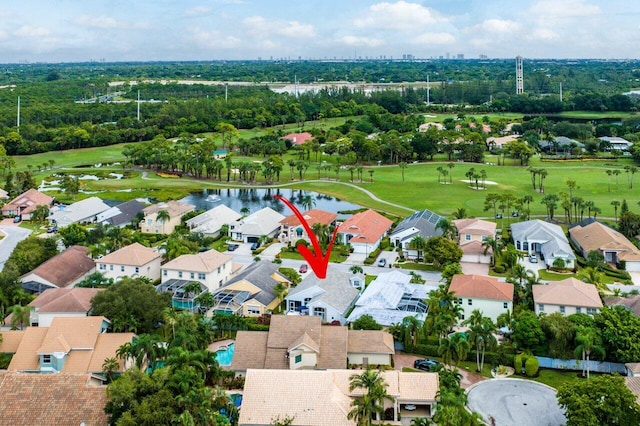 drone / aerial view featuring view of golf course, a water view, and a residential view