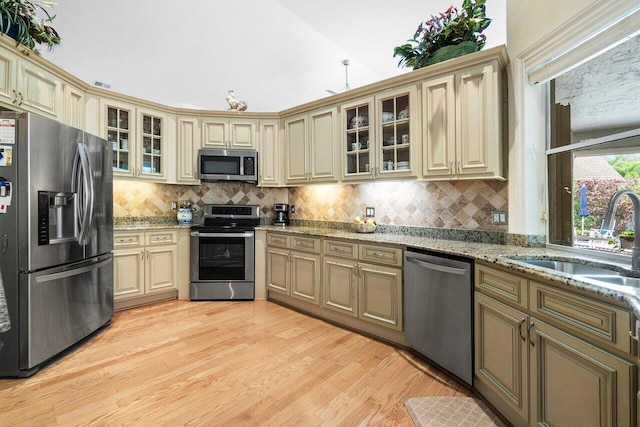 8271 Bob O Link Dr, West Palm Beach, FL 33412 - kitchen featuring appliances with stainless steel finishes, cream cabinetry, a sink, light wood-type flooring, and decorative backsplash