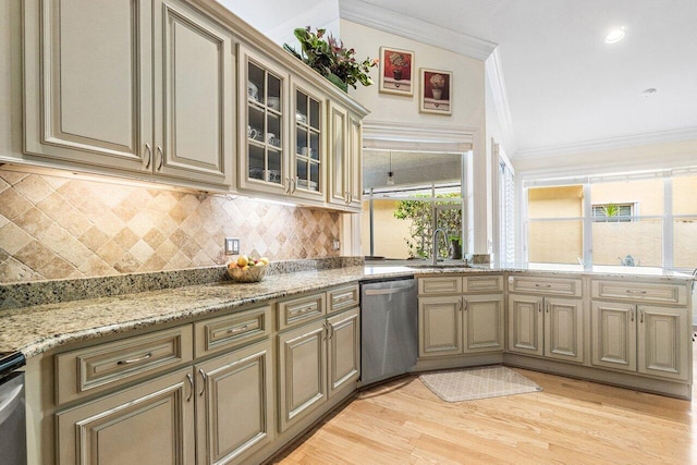 kitchen with crown molding, cream cabinetry, stainless steel dishwasher, and a sink