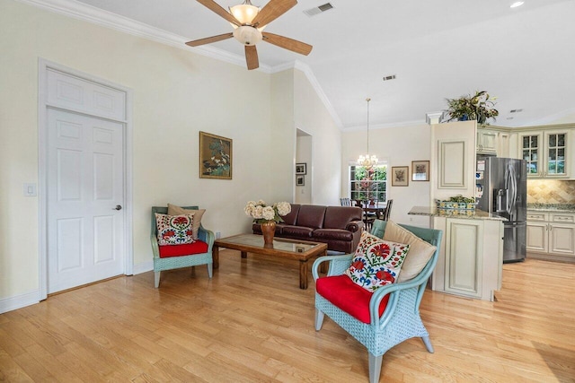 living area with ceiling fan with notable chandelier, visible vents, and light wood-style floors