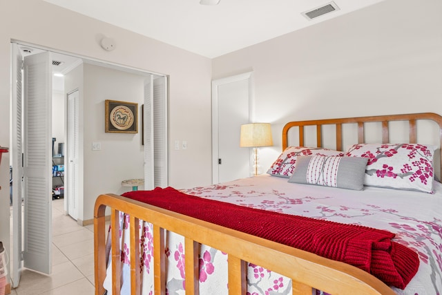 bedroom with a closet, visible vents, baseboards, and light tile patterned flooring