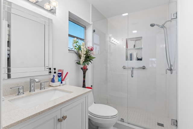 bathroom featuring vanity, toilet, and a shower stall