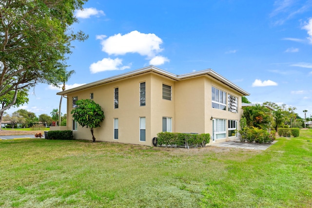 view of side of property with stucco siding and a lawn
