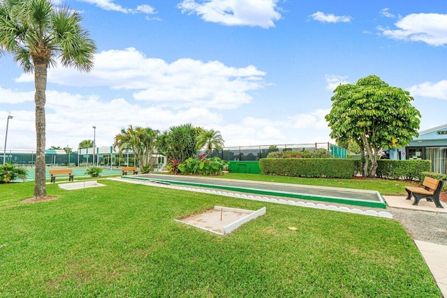 view of property's community featuring a yard and fence