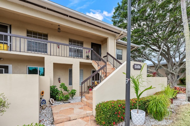 view of property featuring stairs and fence