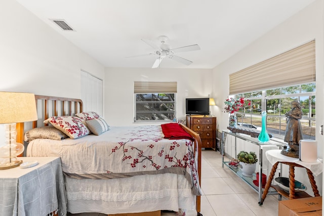 bedroom featuring ceiling fan, light tile patterned flooring, a closet, and visible vents