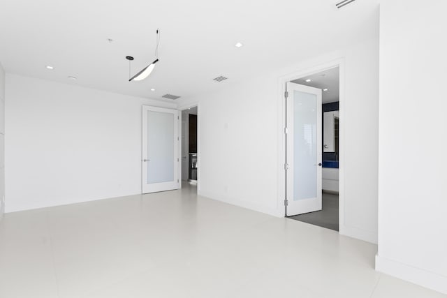 spare room featuring recessed lighting and baseboards