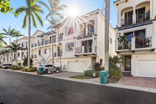 townhome / multi-family property featuring stucco siding, an attached garage, and decorative driveway