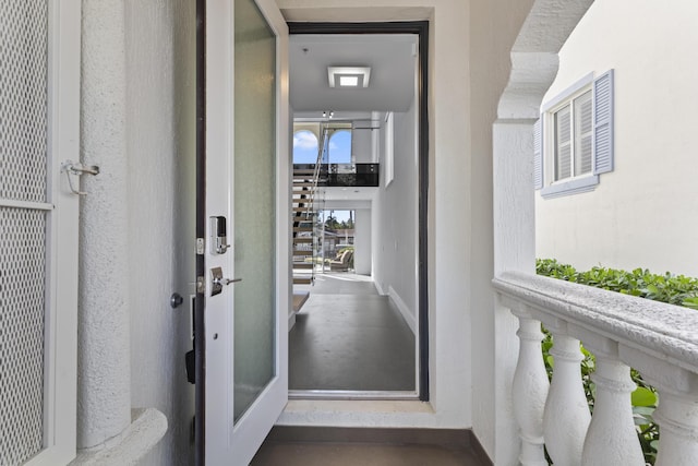doorway to property with a balcony and stucco siding
