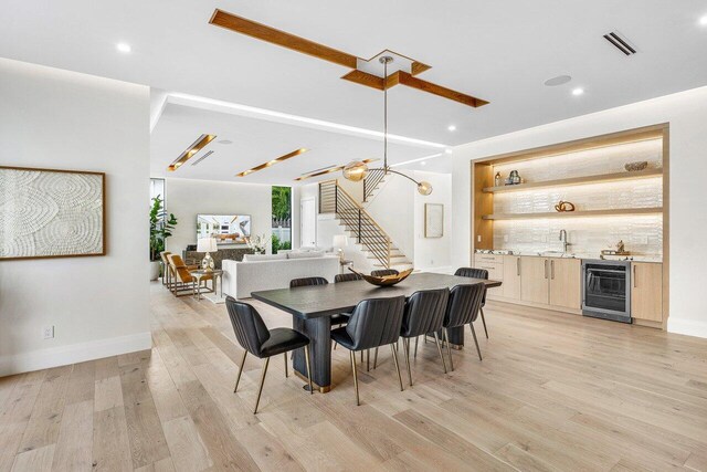 1445 NE 5th Ave, Boca Raton, FL 33432 - dining space featuring beverage cooler, stairway, bar with sink, light wood-style flooring, and recessed lighting