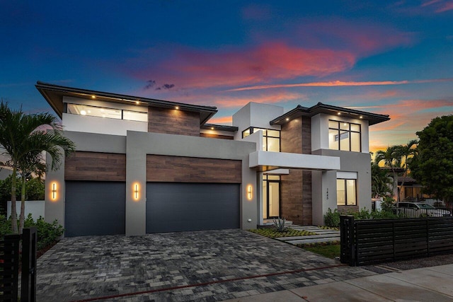 1445 NE 5th Ave, Boca Raton, FL 33432 - contemporary home featuring fence, decorative driveway, stucco siding, stone siding, and an attached garage