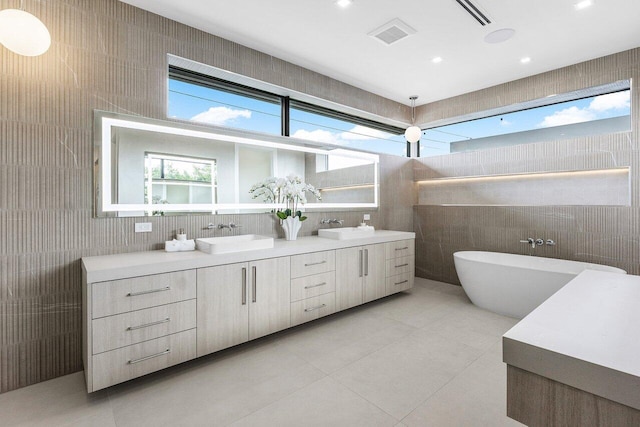 1445 NE 5th Ave, Boca Raton, FL 33432 - full bathroom with tile walls, double vanity, tile patterned floors, a soaking tub, and recessed lighting