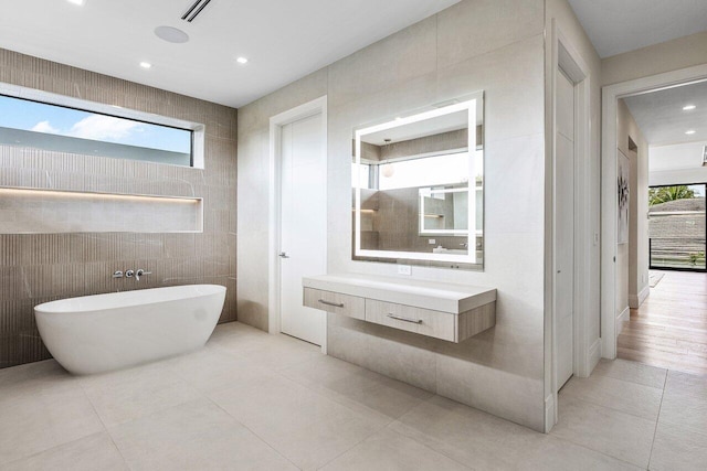 1445 NE 5th Ave, Boca Raton, FL 33432 - bathroom with tile patterned floors, a freestanding tub, healthy amount of natural light, recessed lighting, and tile walls