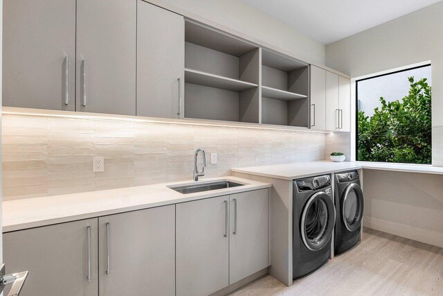1445 NE 5th Ave, Boca Raton, FL 33432 - laundry room featuring cabinet space, washing machine and dryer, baseboards, and light wood-style floors