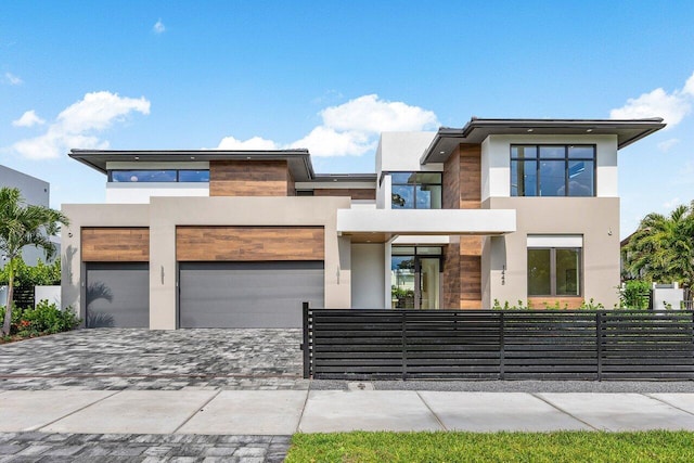1445 NE 5th Ave, Boca Raton, FL 33432 - contemporary home with stucco siding, decorative driveway, and a fenced front yard