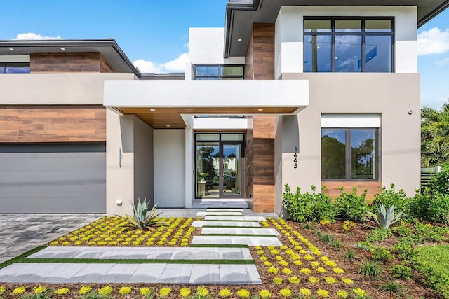 1445 NE 5th Ave, Boca Raton, FL 33432 - contemporary home featuring stucco siding, a garage, a balcony, french doors, and driveway