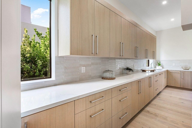 1445 NE 5th Ave, Boca Raton, FL 33432 - kitchen with light brown cabinets, modern cabinets, backsplash, a sink, and light wood-style floors