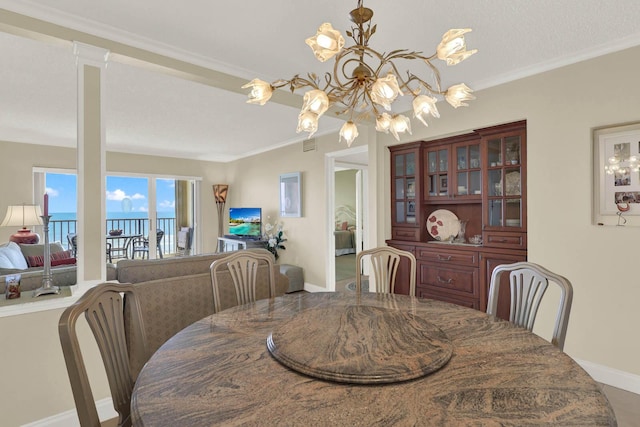 10200 S Ocean Dr Unit 303, Jensen Beach, FL 34957 - dining room with baseboards, crown molding, a chandelier, and visible vents