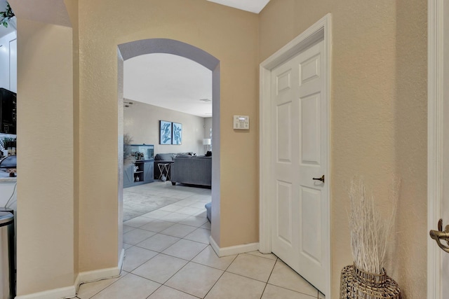 2125 Oakmont Dr, Riviera Beach, FL 33404 - corridor featuring arched walkways, baseboards, and light tile patterned floors